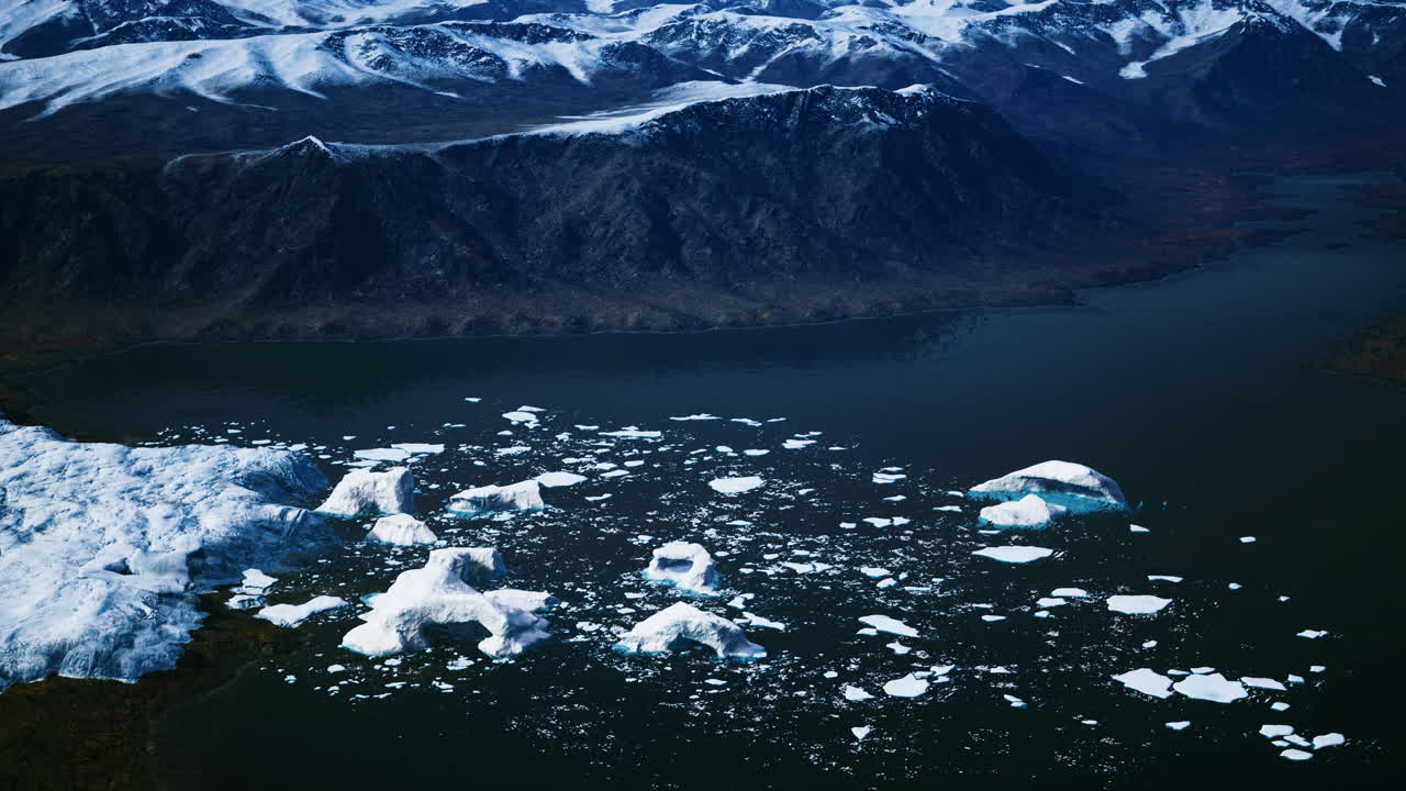 Stunning aerial view of icebergs in a glacial lake surrounded by mountains