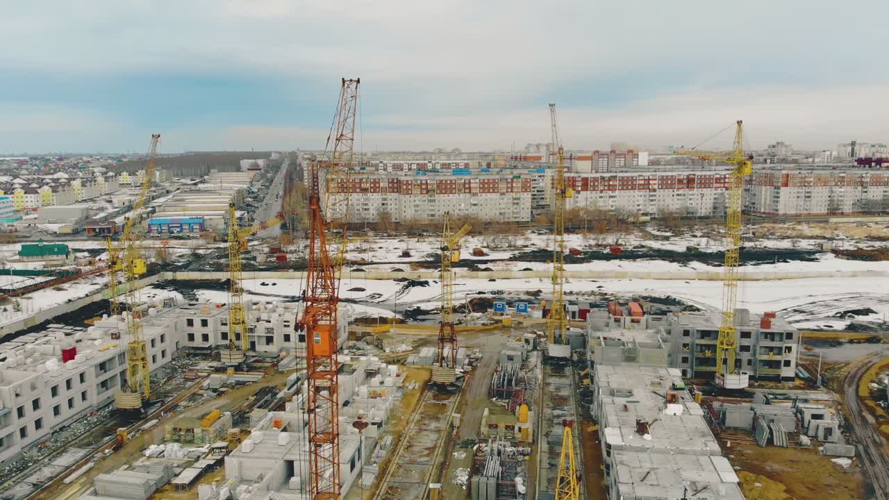 edificios en construcción con grúas contra la ciudad