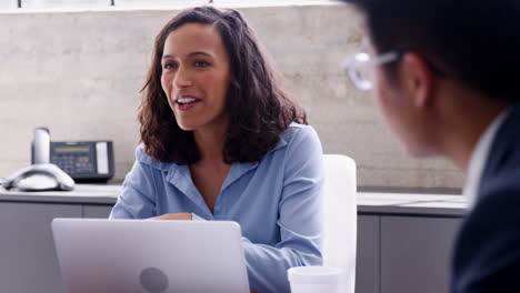 Young-female-boss-talking-to-colleagues-at-meeting,-close-up