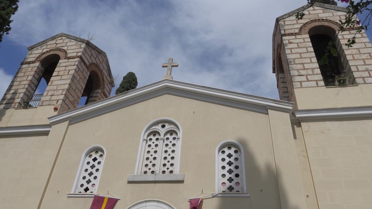 Puerta de entrada de madera y mosaico de Cristo debajo de ventanas arqueadas en la Iglesia de la Metamorfosis Sotiros en Atenas