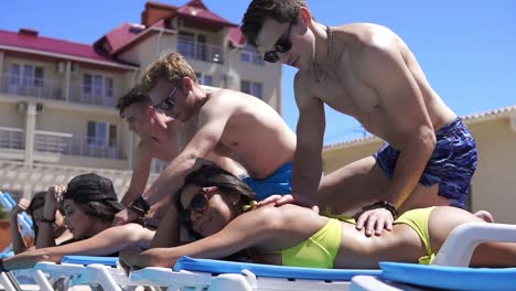 women receiving massage from their boyfriends at a beautiful villa by the pool. slow motion shot