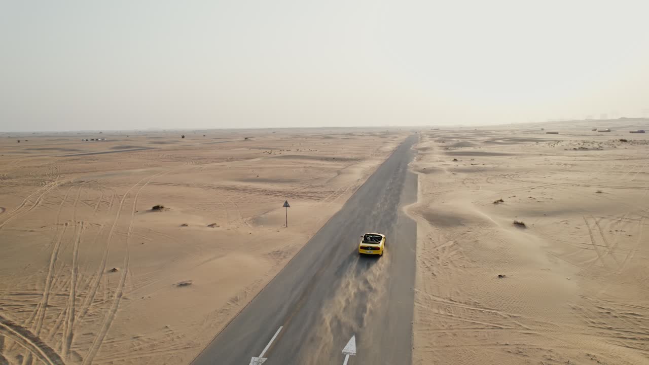 coche amarillo en un camino del desierto
