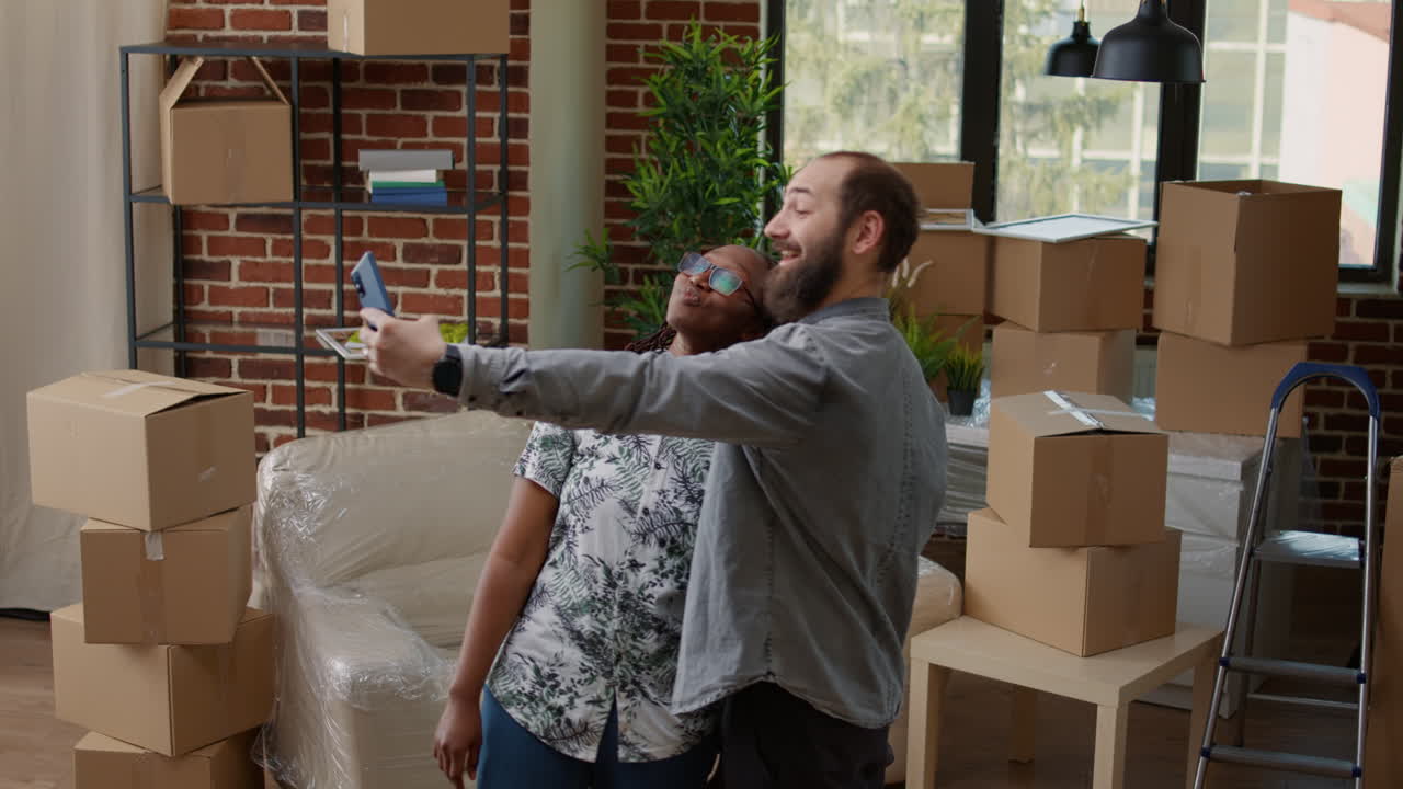 Multiethnic couple recording video in new real estate apartment