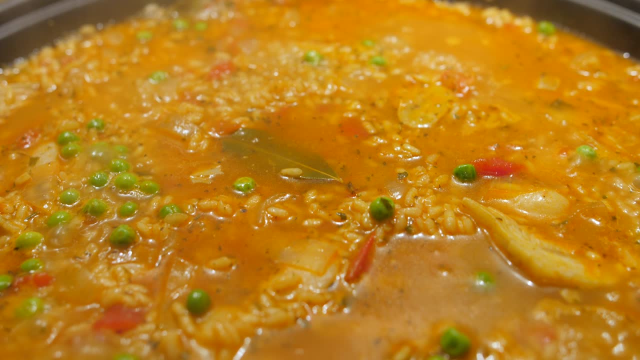 vista de cerca de la comida exótica de arroz frito con zanahorias y guisantes verdes cocinados en una cocina