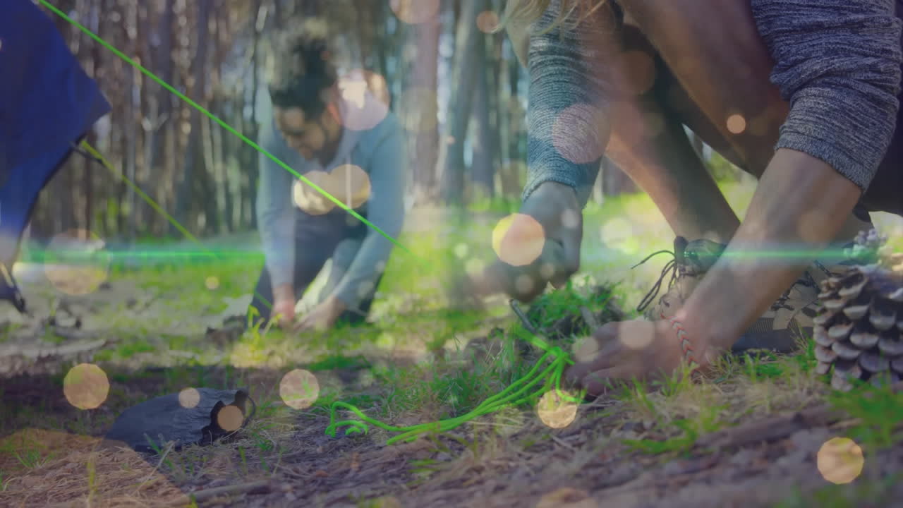 camping companions hammering tent stakes in forest clearing, with travel icons and data overlays