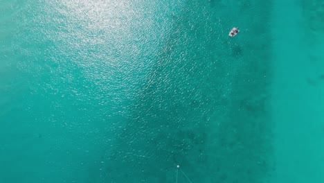 Luftaufnahme-Von-Oben-Nach-Unten-Mit-Drohnenansicht-Des-Kristallklaren-Wassers-Der-Bahamas-Mit-Segelbooten,-Die-Bis-Zum-Horizont-Schwenken