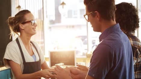 waitress serving black tea to two friends