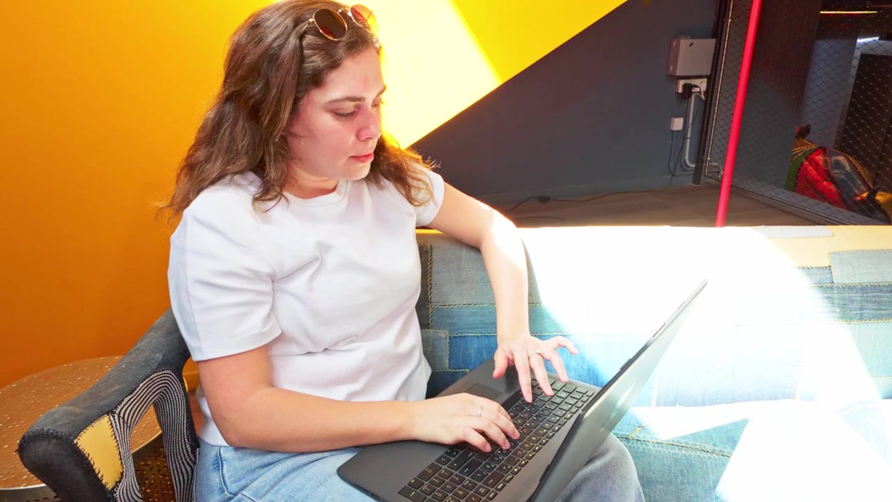 Donna freelance che lavora al laptop in una lobby di coworking