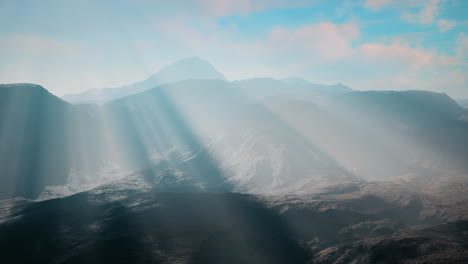 sunbeams breaking through the clouds over majestic mountains