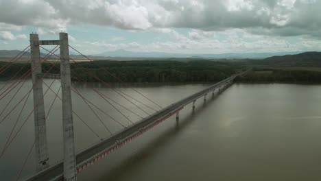 Gran-Estructura-De-Puente-Que-Cruza-Un-Río-Que-Fluye-Rápidamente-En-Los-Trópicos-En-Un-Día-Nublado