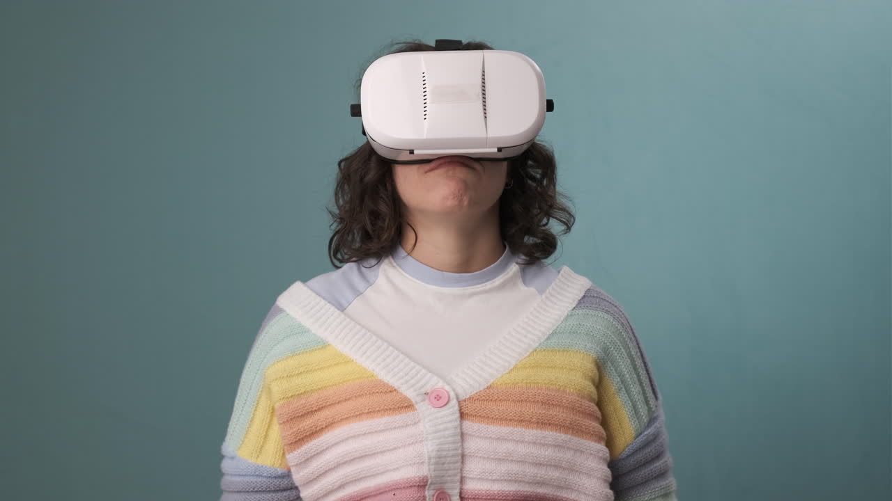 Woman showing thumb down while using VR virtual reality headset over an blue background.