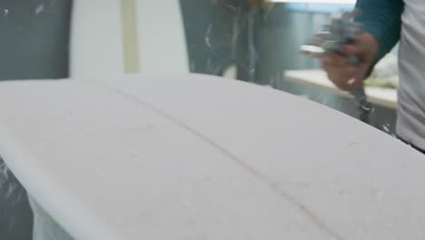 un hombre que hace tablas de surf en su taller