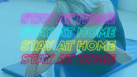 animation of four lines of colourful neon words stay at home over caucasian woman exercising