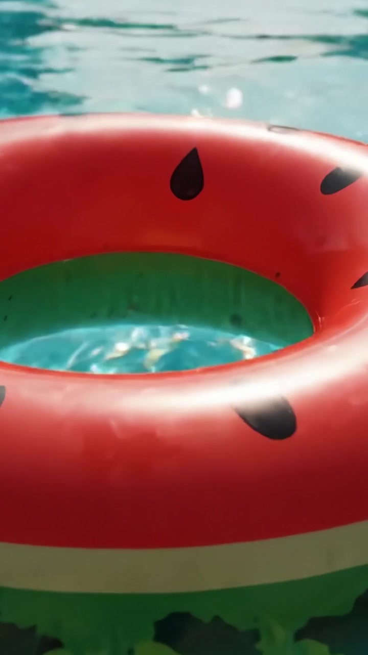 Colorful Watermelon Pool Float Floating in Crystal Clear Water, Capturing the Essence of Summer Fun and Relaxation in a Vibrant Pool Setting