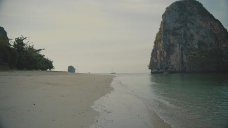 Aguas-Tranquilas-Del-Mar-En-La-Playa-Remota-En-El-Ferrocarril-Con-Acantilado-En-Segundo-Plano