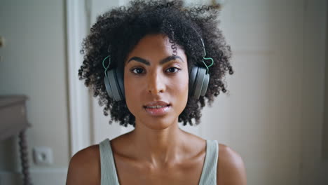 portrait yoga girl inhaling at home. african headphones woman meditating alone