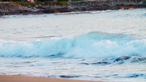 el movimiento lento de las olas que llegan a tierra