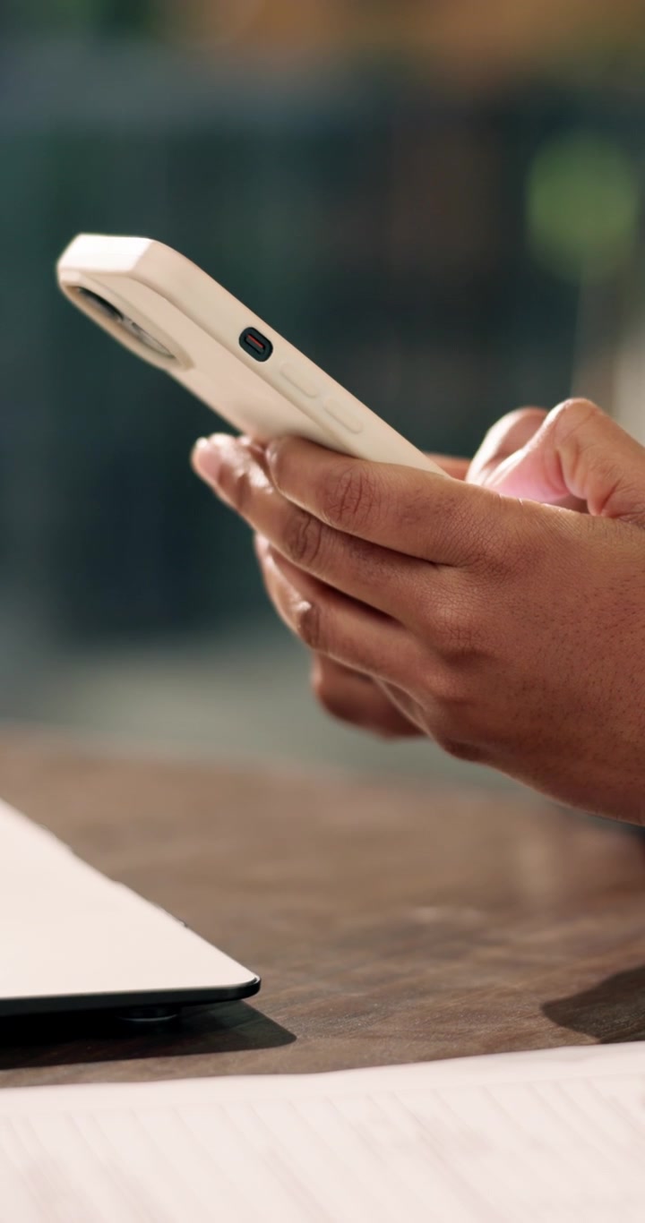 Persona che usa lo smartphone alla scrivania in ufficio