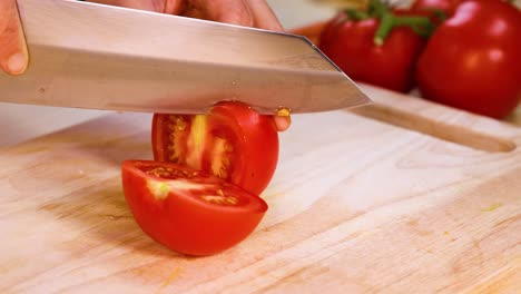 a tomato is sliced with a sharp knife