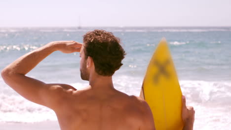 Un-Hombre-Mira-El-Mar-Con-Su-Tabla-De-Surf