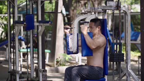 man exercising on a chest press machine at an outdoor gym