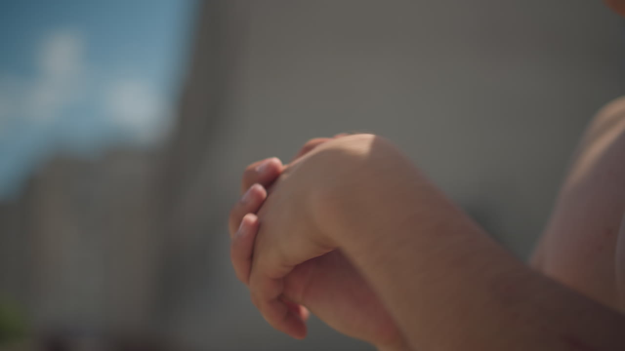 맞잡은 손과 고요한 하늘의 디테일 뷰, 클로즈업으로 분필이 묻은 손가락과 평온한 하늘 배경을 제대로 포착하여 평화로운 하늘을 배경으로 분필을 든 손을 강조하는 친밀한 장면