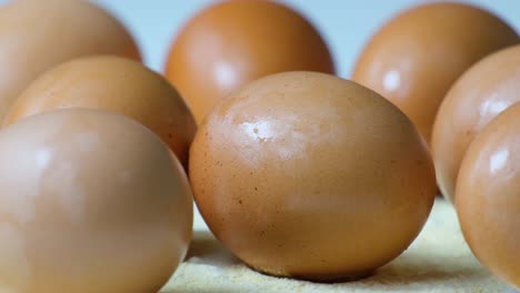 close-up shot of brown poultry chicken eggs rotating in the shot - brown asian chicken eggs