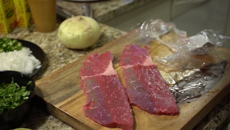 laying out steak on a wooden cutting board in slow motion