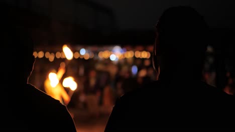 火を見ている男は男の背中を示す