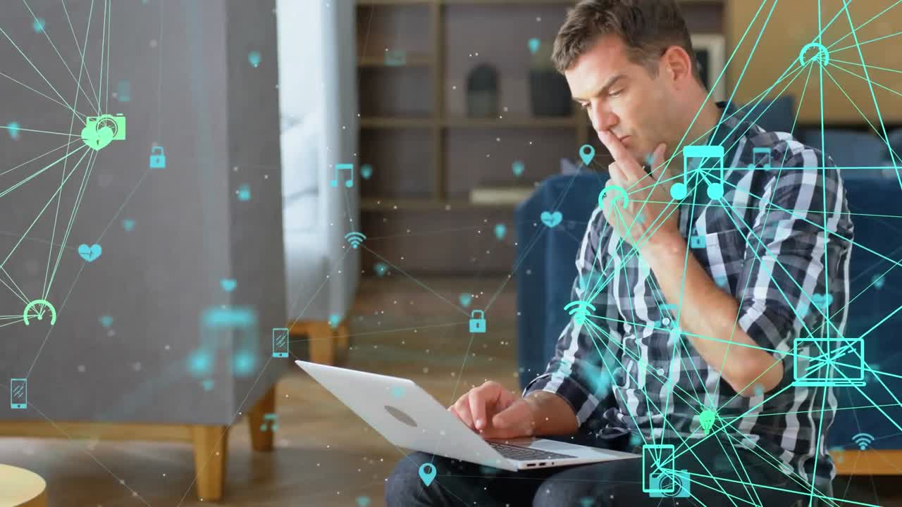 animación de globos de iconos digitales girando sobre un hombre caucásico pensativo usando una computadora portátil en la oficina