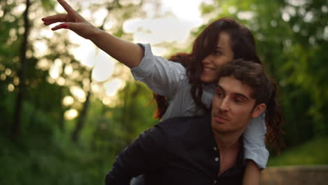 una pareja juguetona de primer plano divirtiéndose durante una caminata juntos en el parque de verano.