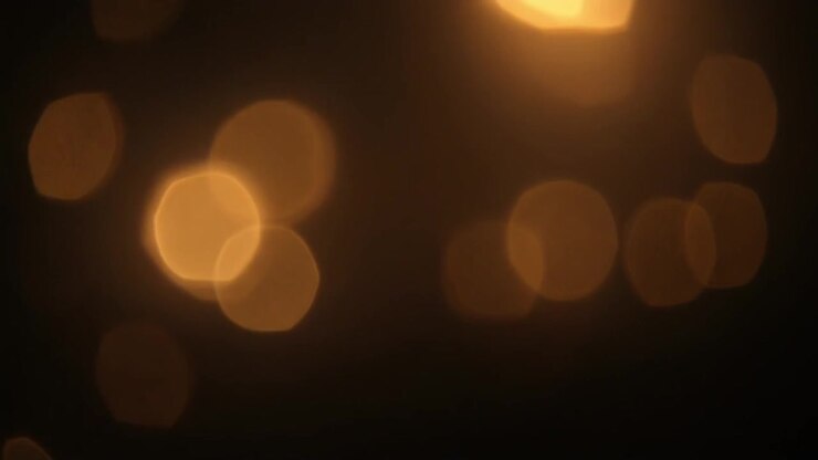 Luci bokeh dorate astratte scintillanti su sfondo scuro