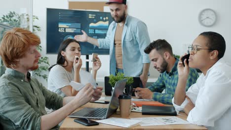 unmotivated employees ignoring business meeting and boss chatting on mobile phones and playing games