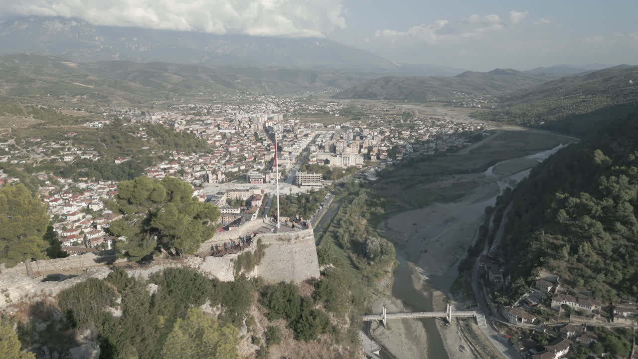 un drone scatta la città di berat e il suo castello e fortezza in albania, la città delle mille finestre in una giornata di sole nella valle con cielo blu con case bianche vicino alle montagne