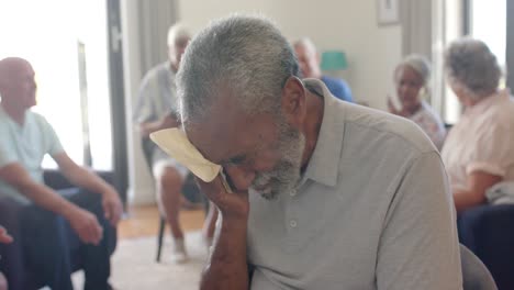 ancianos diversos angustiados llorando y hablando en sesión de terapia de grupo, sin alteración, cámara lenta