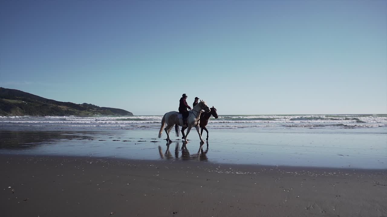People riding horses on the beach