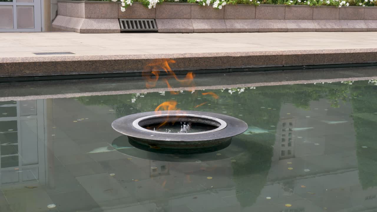 Close-up slow motion Eternal Flame fire pit in water pond of the Australian War Memorial museum monument in Canberra ACT soldiers remembrance honour monument architecture Anzac Day