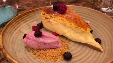 pastel de queso vasco tradicional español quemado con bayas y helado, postre cremoso dulce en un plato, tiro de 4k