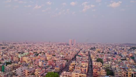 crowded independent houses with gated community tower buildings, sky and haze at jagathgiri gutta, hyderabad, telangana, india. day time, tilt down, drone shot, 4k.
