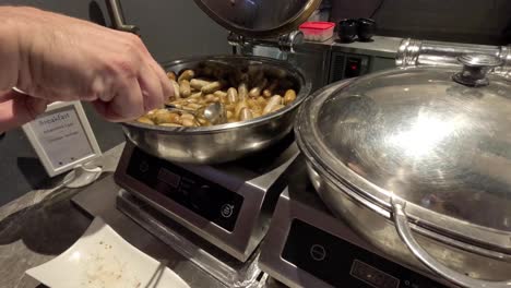 person serving food at a buffet station