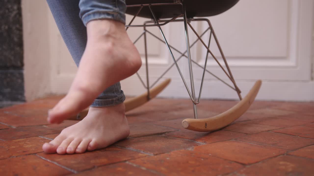 A Woman's Feet Gently Swaying the Rocking Chair - Close Up