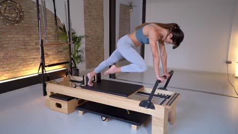 Frau-Streckt-Beine-Auf-Pilates-Reformer