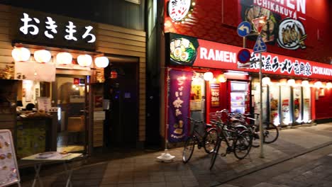 nighttime view of a lively urban ramen restaurant