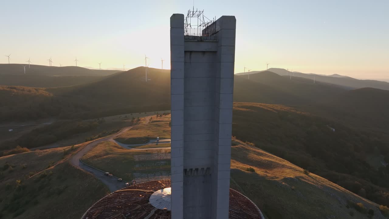 Cupola fatiscente di Buzludzha sopra creste ondulate all'alba, Bulgaria