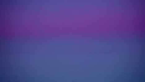 Timelapse-shot-of-snow-covered-farmlands-covered-dense-fog-with-pine-trees-swaying-in-the-wind-in-the-background-on-a-cloudy-winter-morning