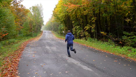 Mann-Läuft-Auf-Einer-Kleinen-Straße,-Umgeben-Von-Ahorn-Herbst-Maple-Leaf-Slowmotion-1