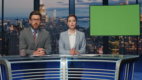 진지한 진행자 들 이 이야기 하고 있는 그린 스크린 뉴스 들 이 서 있는 저녁 tv 스튜디오 클로즈업