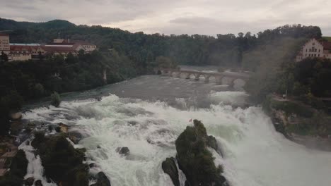 Drohnenaufnahme-Fliegt-Direkt-Nach-Oben-Mit-Nach-Unten-Geneigter-Kamera-Am-Großen-Wasserfall-Rheinfall-In-Der-Schweiz-In-4k