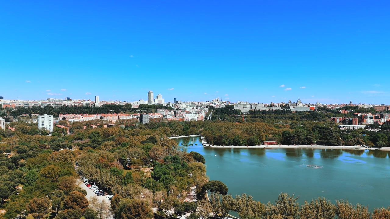 Luftpanorama over Casa de Campo-søen mod Madrids centrale skyline.