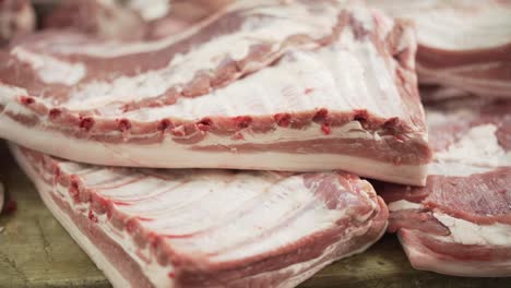 fresh piece of pork ribs carried by hands of butcher